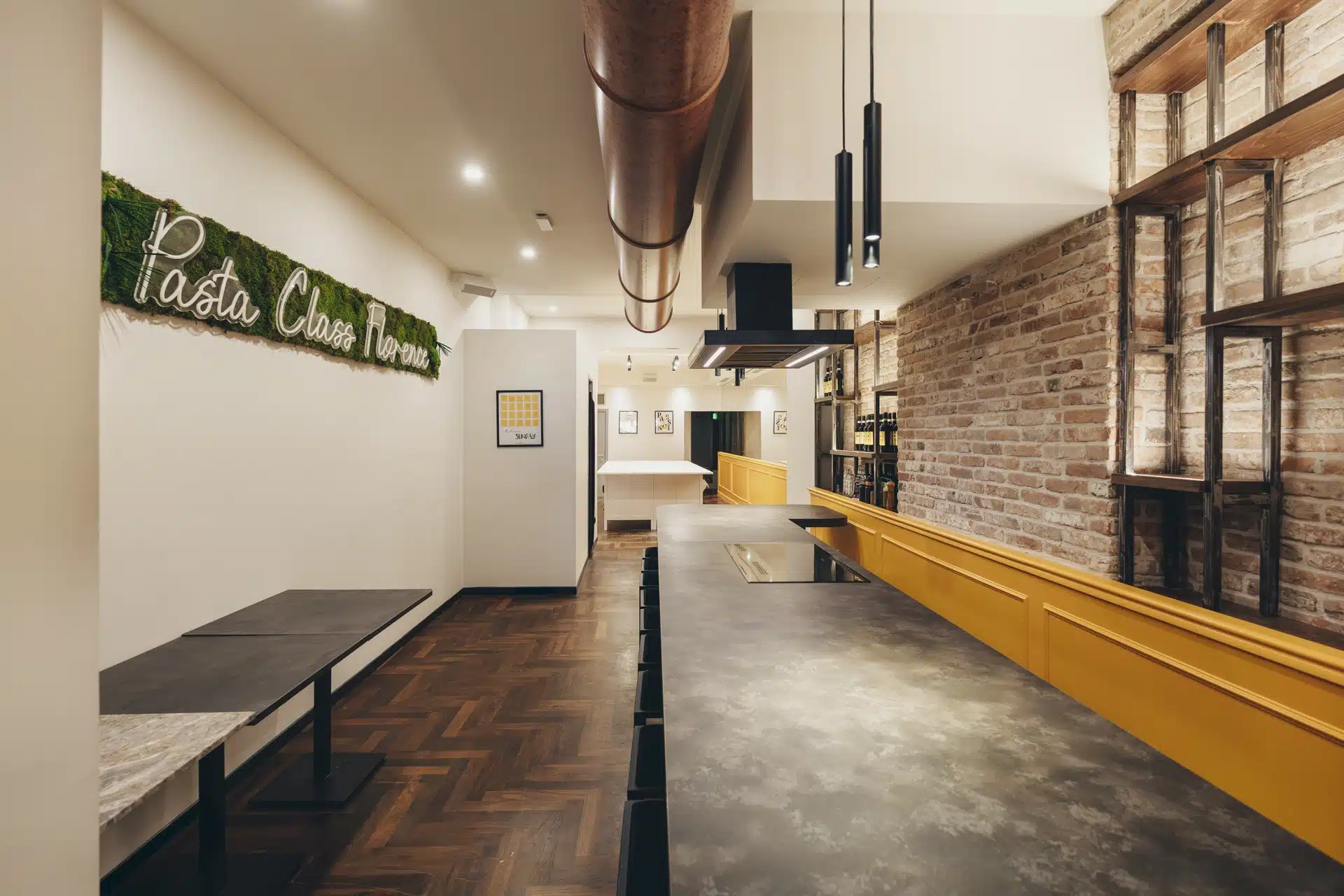 un tavolo, una panchina ed una sala per fare le cooking classes