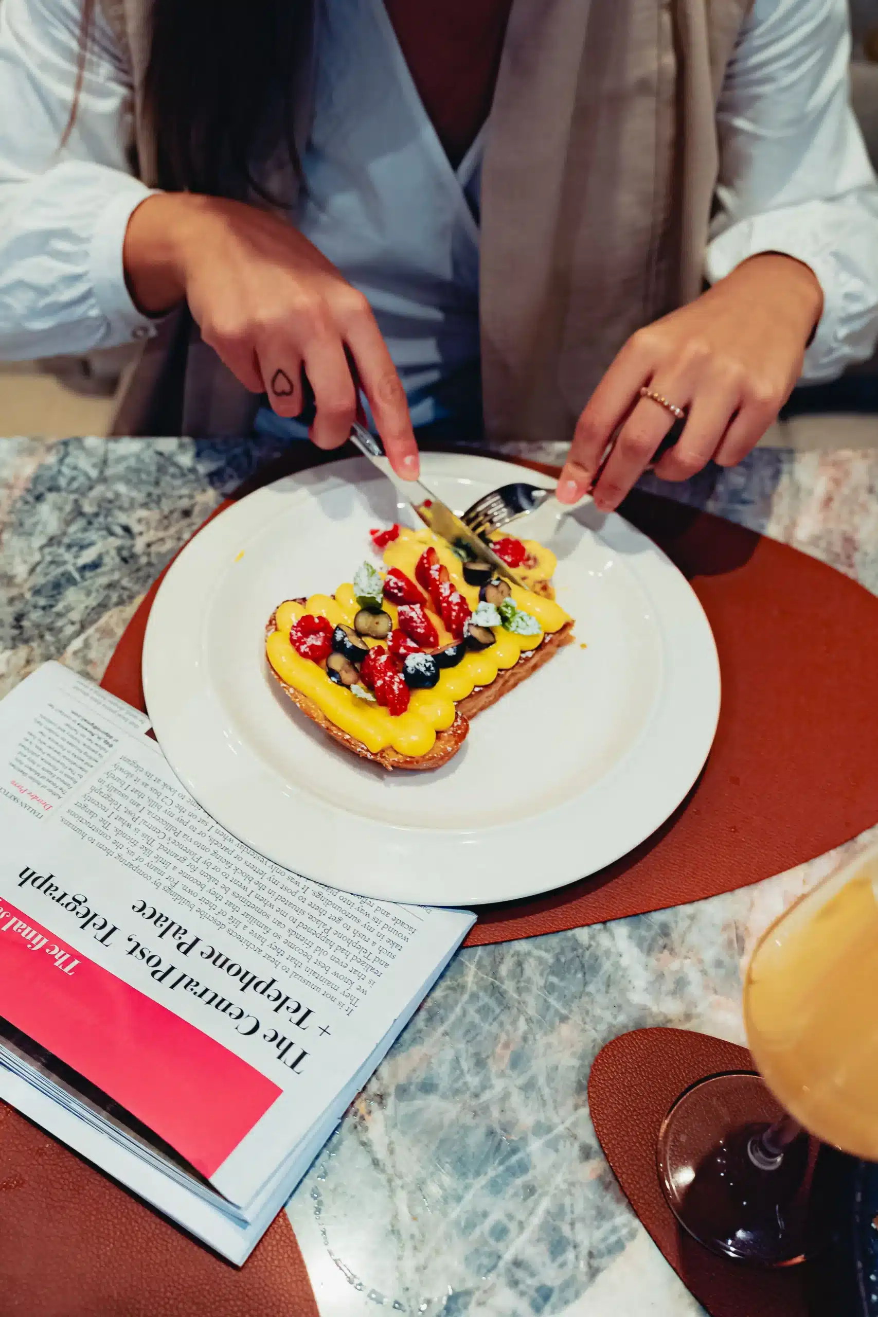 persona che taglia una torta a porzione singola con la frutta sopra