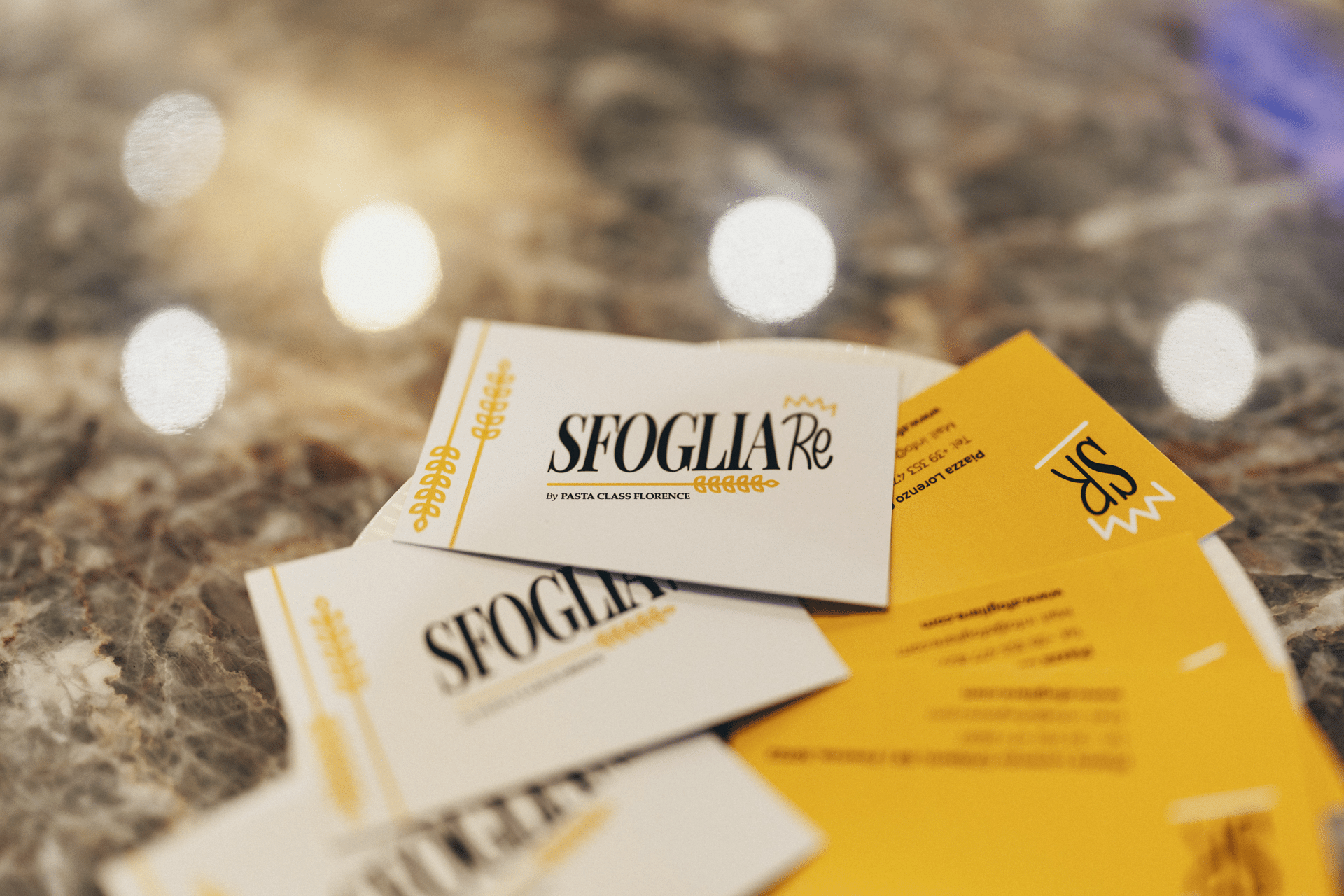 Sfoglia Re restaurant business cards with the logo on a marble table in Florence