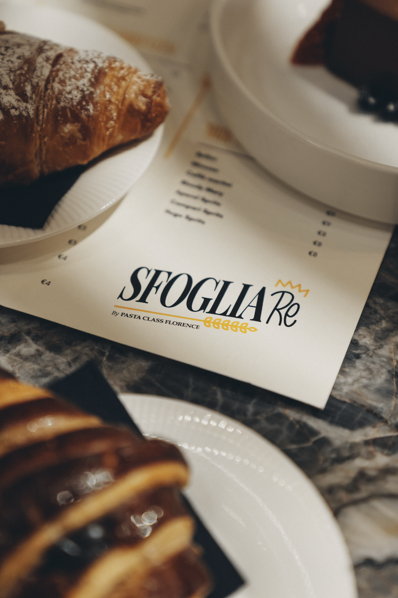 Menu brunch di Sfoglia Re con croissant e dolci su un tavolo di marmo a Firenze