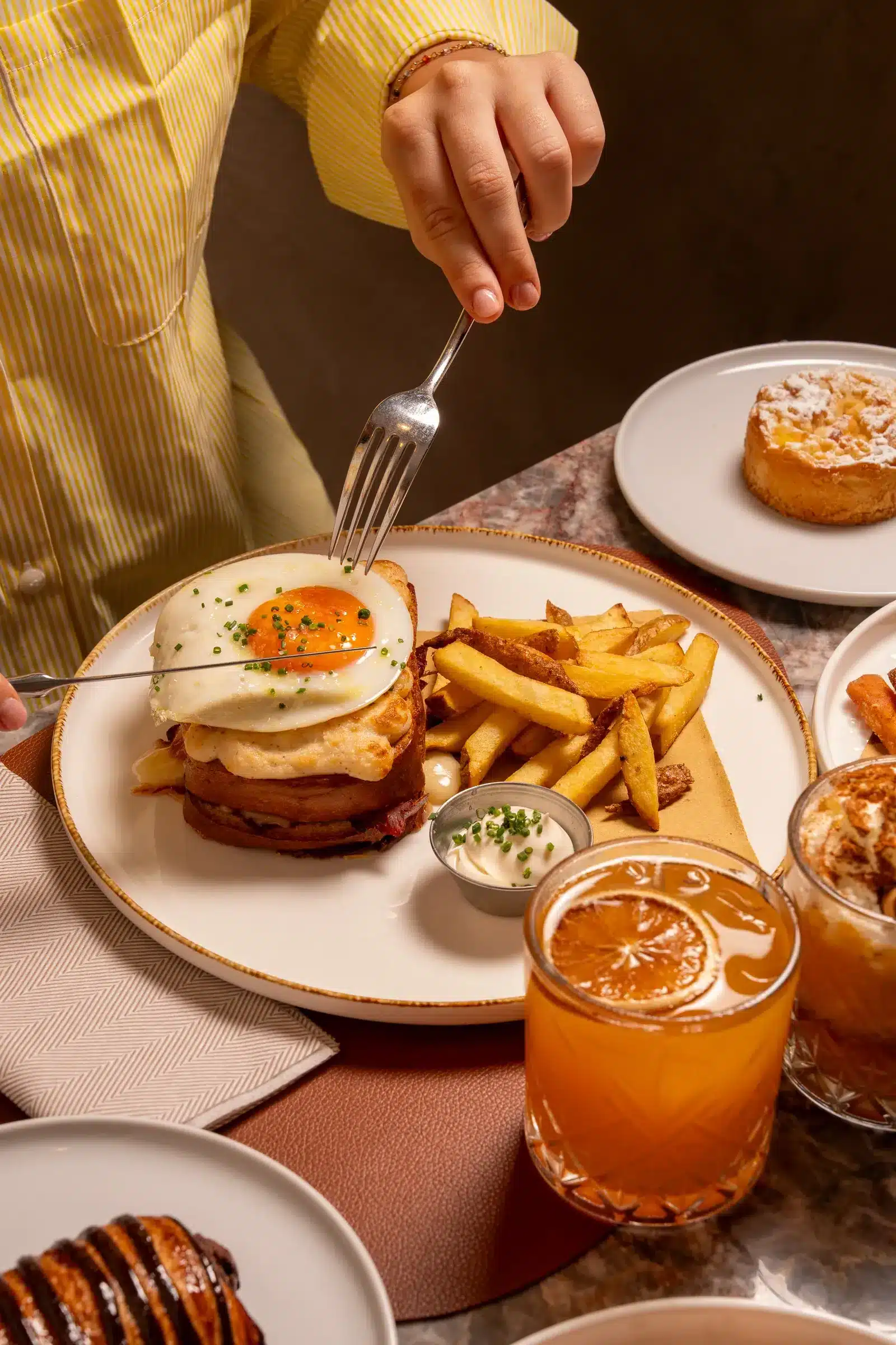 Brunch con croque madame, patatine e succo