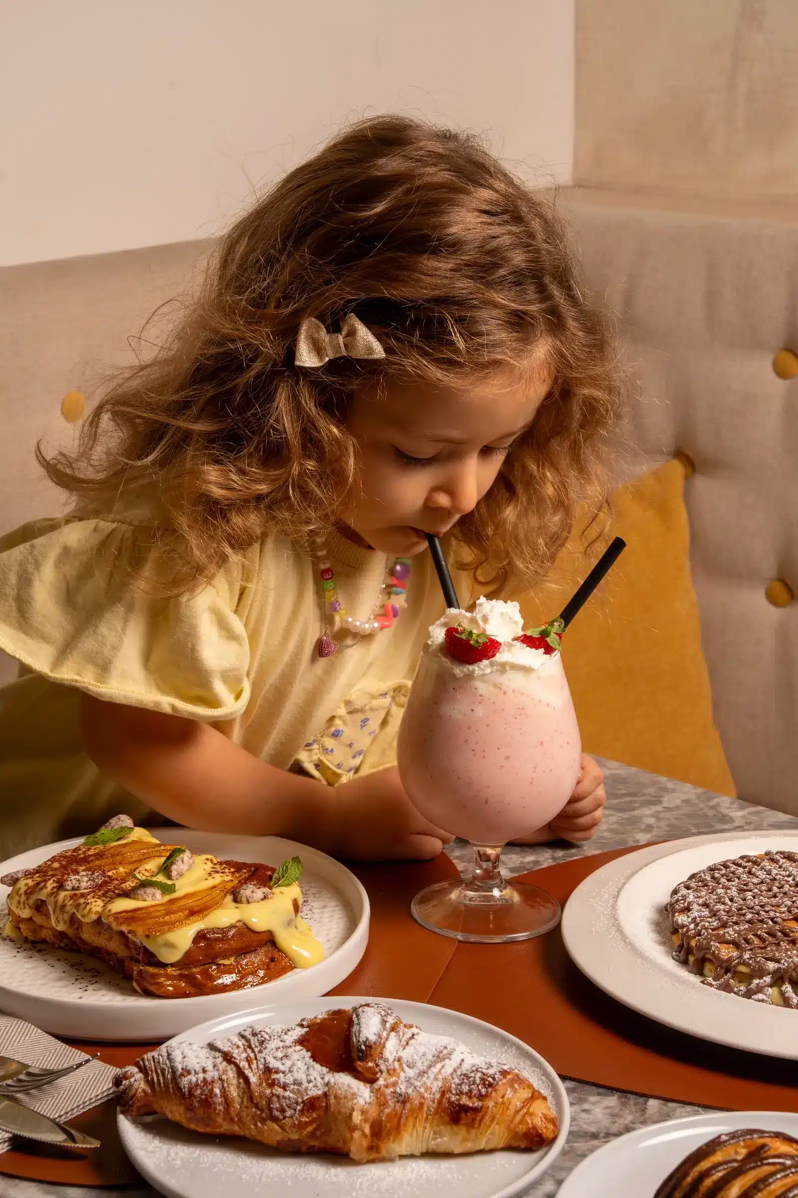 Bambina che beve un frappè a colazione da Sfoglia Re