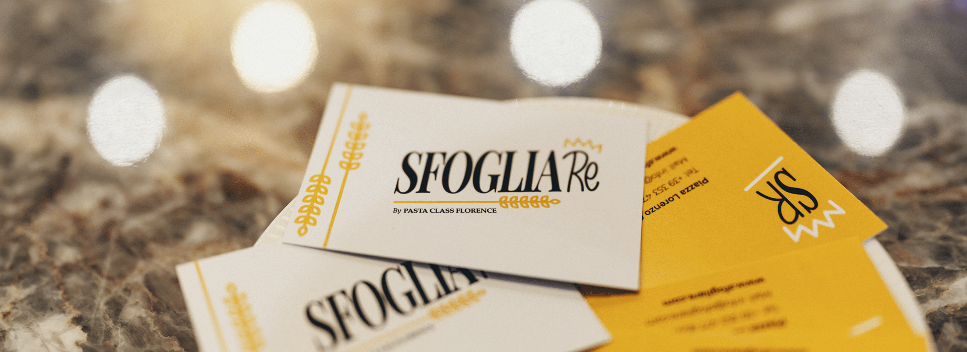 Sfoglia Re restaurant business cards with the logo on a marble table in Florence