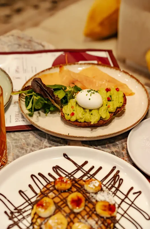 avocado toast su un piatto e pancakes sull'altro