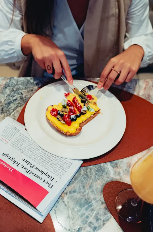 persona che taglia una torta a porzione singola con la frutta sopra